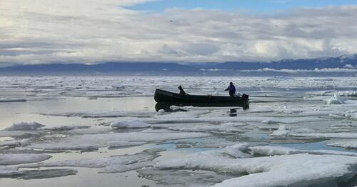 Inuit harvesters boating along the shore of Mittimatalik (Pond Inlet), Nunavut, Canada