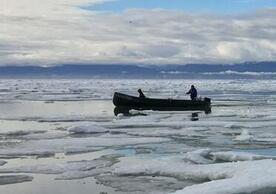 Inuit harvesters boating along the shore of Mittimatalik (Pond Inlet), Nunavut, Canada
